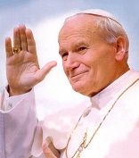 Image of Deacon Keith Fournier standing under the beautiful bronze statue of John Paul II in Denver, Colorado.